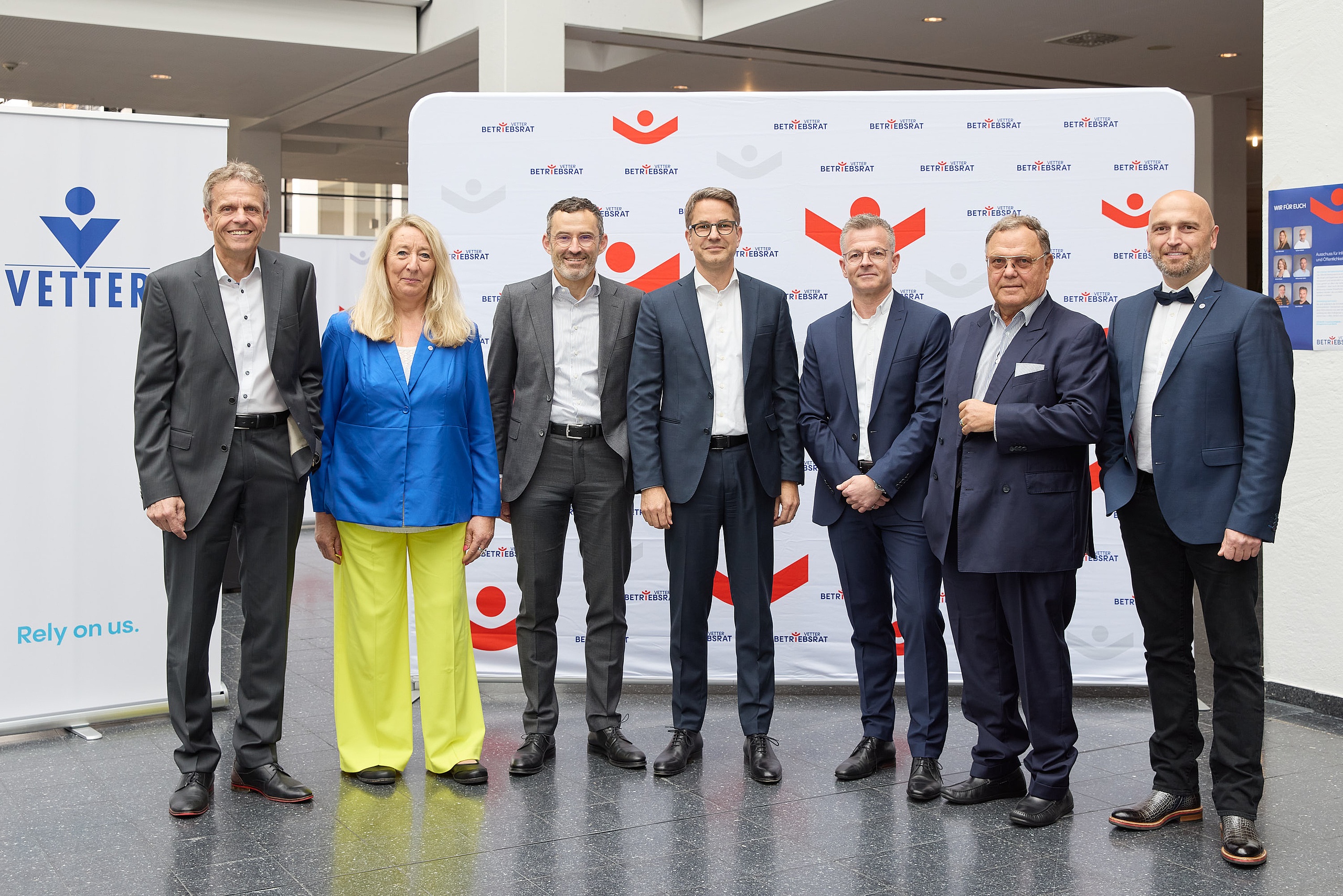 Senator h.c. Udo J. Vetter, Beiratsvorsitzender und Mitglied der Inhaberfamilie (zweiter von rechts), mit den Geschäftsführern Thomas Otto (erster von links), Titus Ottinger (dritter von links), Carsten Press (vierter von links), Henryk Badack (dritter von rechts), sowie den Betriebsratsvorsitzenden Claudia Schmidt und Aydogan Köse (erster von rechts) bei der Vetter-Betriebsversammlung 2025