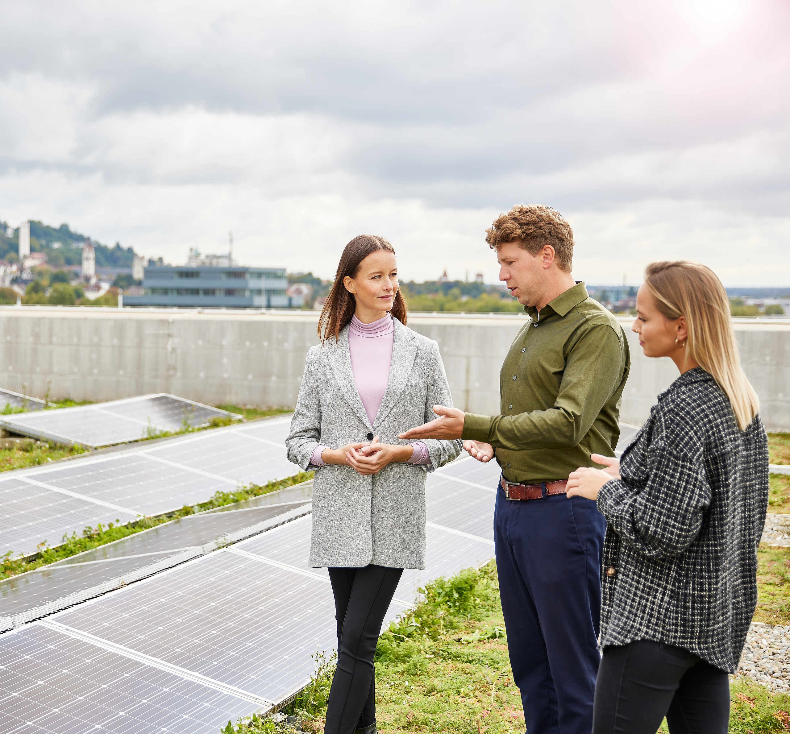 Mitarbeitende auf einem Dach die über die Photovoltaik sprechen 