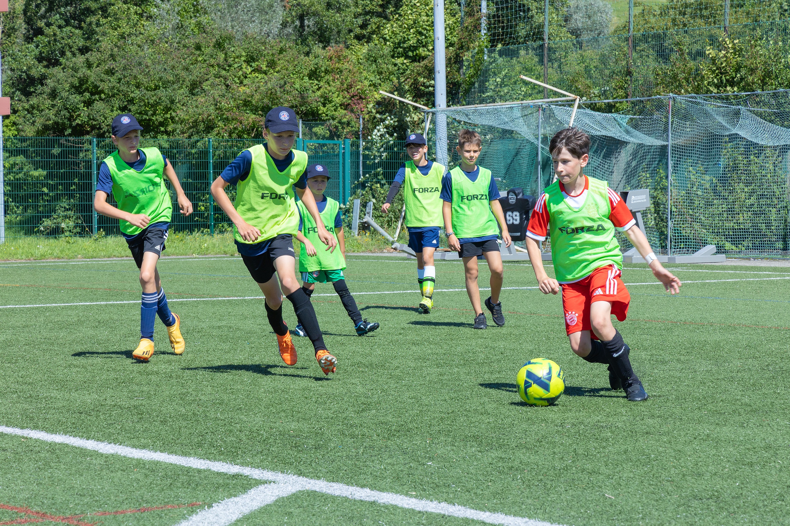 Kinder die zusammen Fußball spielen 