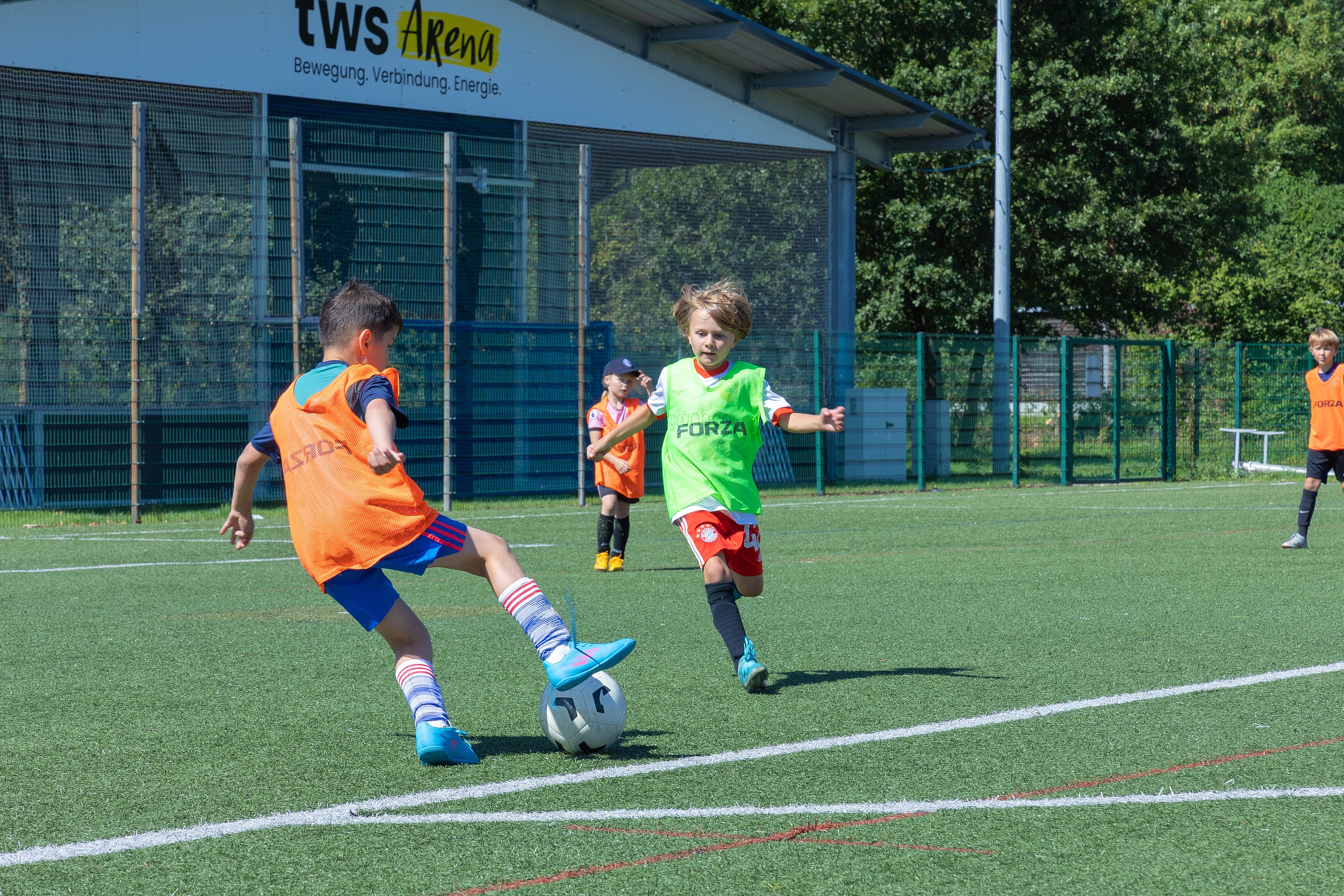 Kinder die zusammen Fußball spielen 