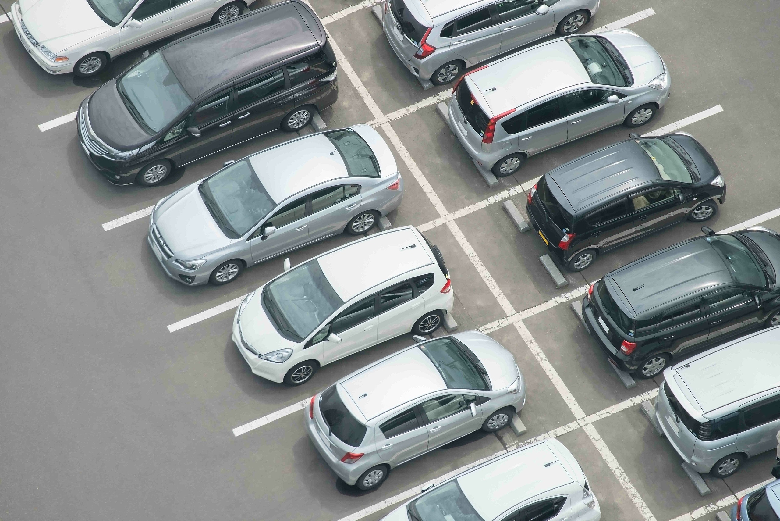 Verschiedene Autos die in gekennzeichneten Parkplätzen stehen 