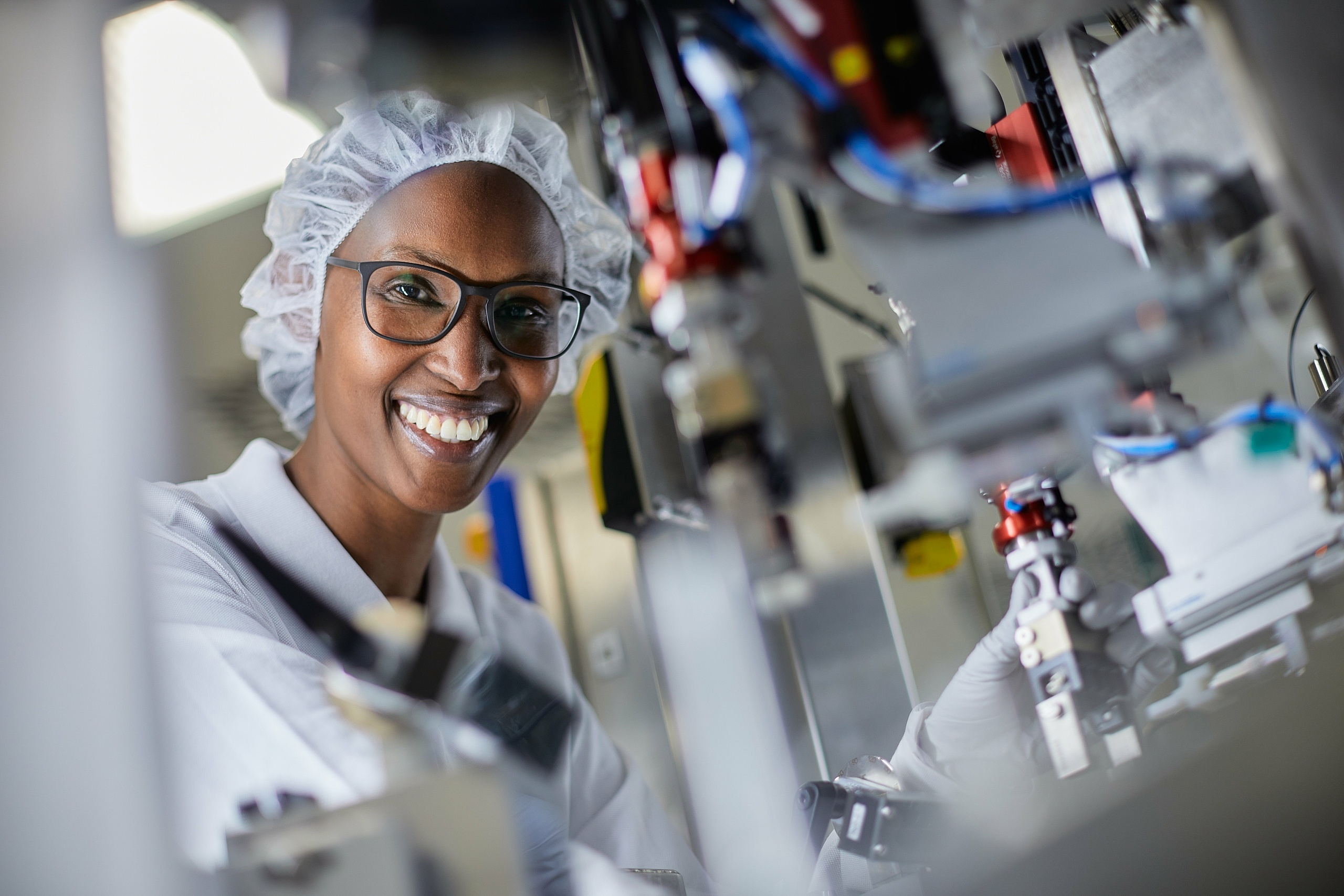 Eine Mitarbeiterin die an einer Maschine in einer Produktion in Ravensburg Süd - Mariatal arbeitet 