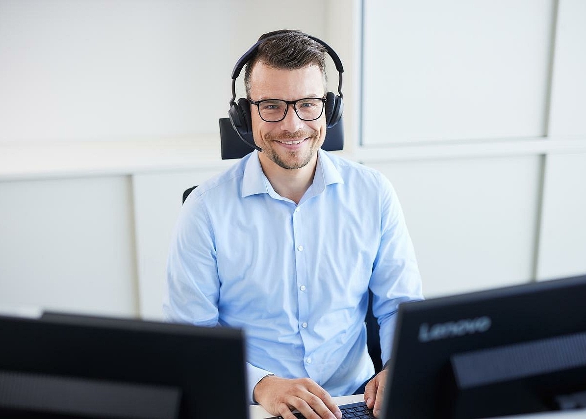 Mitarbeiter der an seinem Arbeitsplatz in der Verwaltung sitzt 