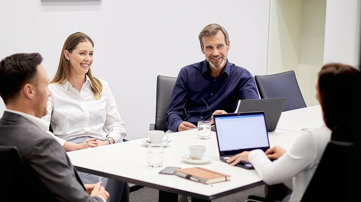 Mitarbeitende in einem Besprechungszimmer 