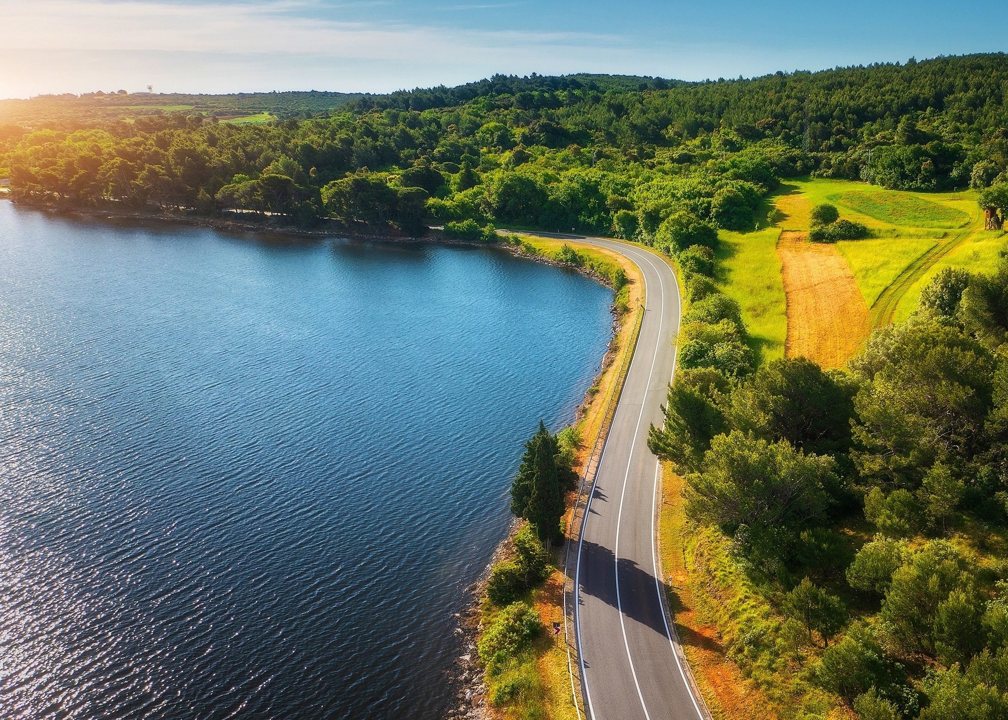 Coverbild des Nachhaltigkeitsberichts 2024 von Vetter mit einer Straße, die am Wasser entlangführt