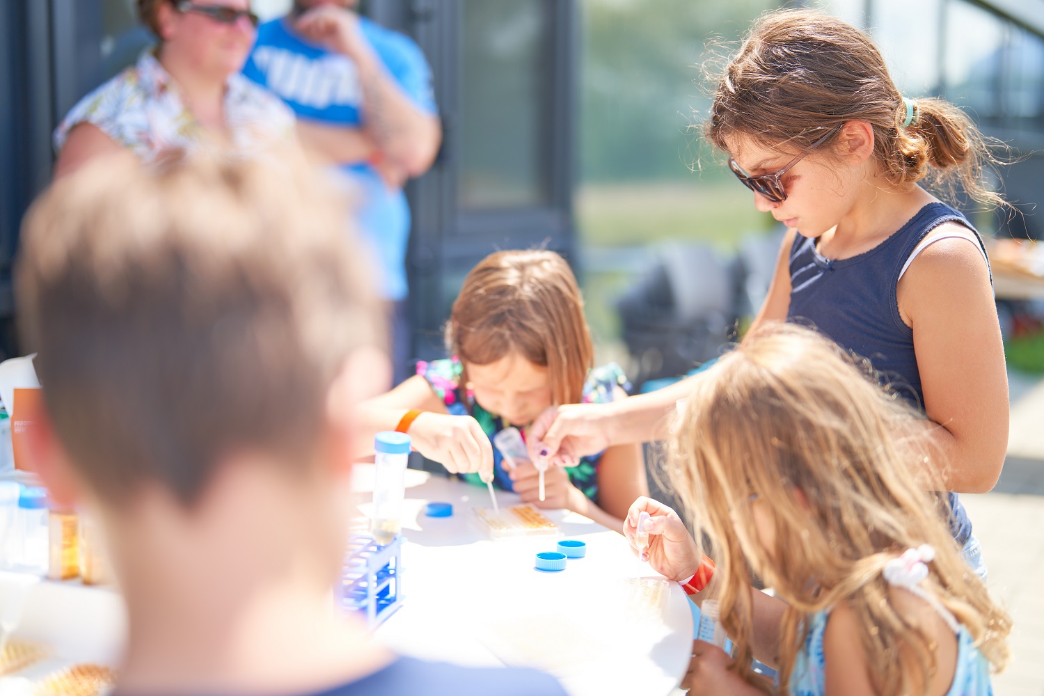 Kinder zusammen an einem Tisch die Seifenblasen herstellen  