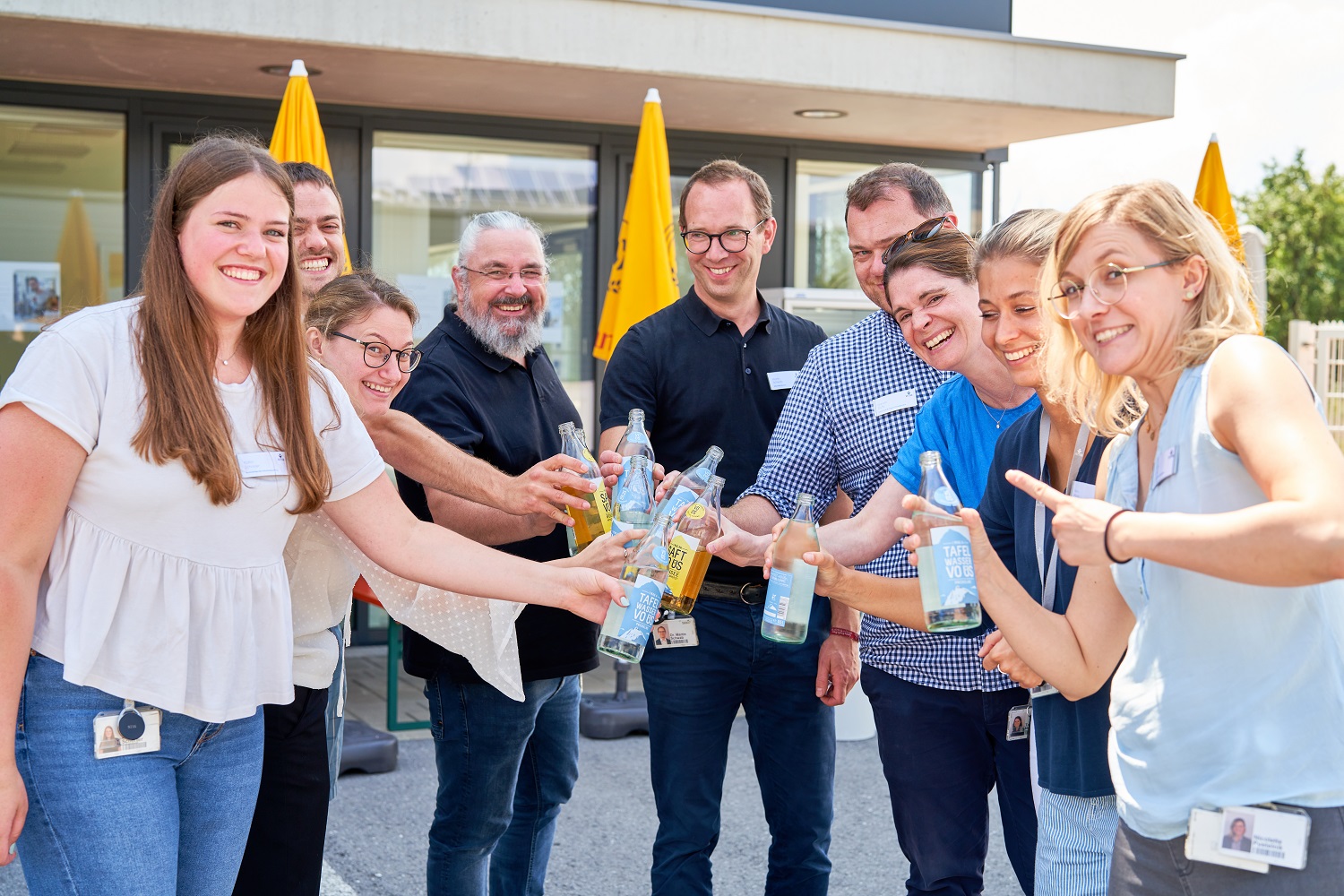 Gruppenbild von Mitarbeitenden die mit Getränken anstoßen